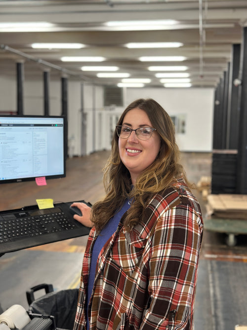 Courtney, C. Richard's customer service team member, smiling at her computer workstation